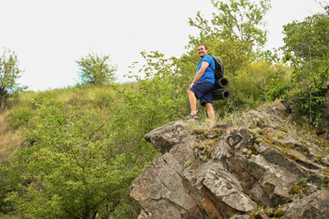 Obraz premium man in sports suit with backpack doing active sports on mountain