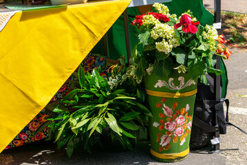 Folk-style flower arrangement in painted pot at outdoor market