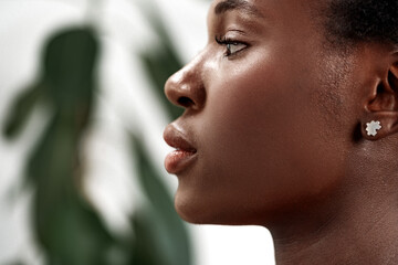 Portrait of a woman showing profile with natural beauty against a blurred background of leaves