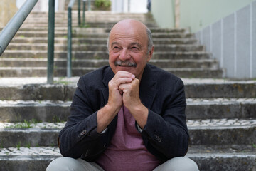 Elderly Man Sitting on Stair Steps, Resting and Remembering His Youth