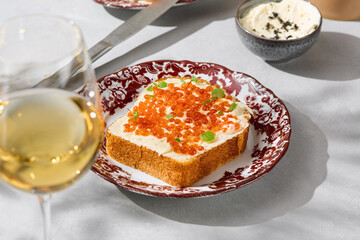 Brioche with butter and red caviar, bright lighting, overhead composition