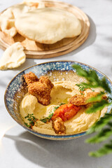 Hummus with chicken strips and pita, bright lighting, overhead composition