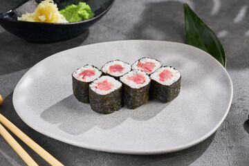 Tuna hosomaki sushi rolls on bright rustic plate, overhead composition for Japanese restaurant menu