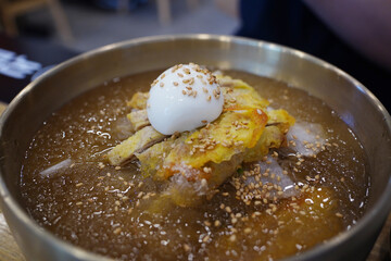 Close-up of Korean Naengmyeon Cold Noodles Topped with Sliced Beef Pancake (Yukjeon)