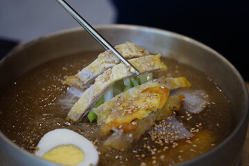 Close-up of Korean Naengmyeon Cold Noodles Topped with Sliced Beef Pancake (Yukjeon)