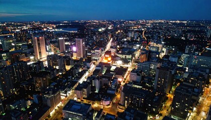 Obraz premium Illuminated cityscape at dusk; aerial view with skyscrapers and streetlights