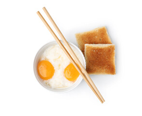 Half-boiled egg in bowl, chopsticks and toasted bread isolated on white, top view. Traditional asian breakfast