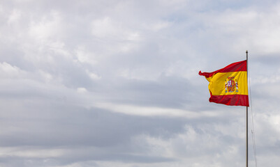 Spanish flag waving on a windy, cloudy day.