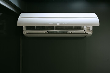 Modern air conditioning unit mounted on a dark wall in a contemporary indoor setting during daytime