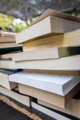 A collection of old books on a table at a fair. Stories written on paper.