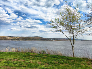 Scenic view of a tranquil river and lush landscape under a partly cloudy sky