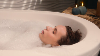 Caucasian woman girl lady rest in spa candles resort bathtub beauty procedure moisturize foam...