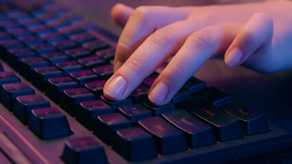Close up female hands arms typing laptop using computer mouse playing virtual video game play...