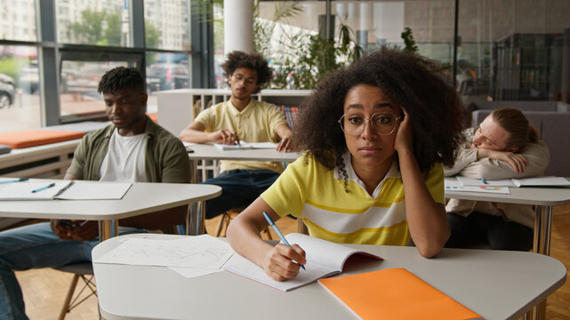 University high school students college lecture class lesson sad boring African American guys males men boys Caucasian girls women females ladies boredom suffer listening teacher study bored education - Powered by Adobe