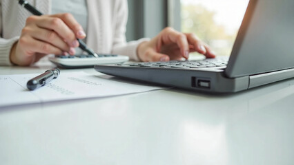 Fototapeta premium Close-up of hands using calculator and laptop for financial work