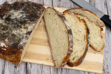 Sliced rustic homemade bread on wooden board