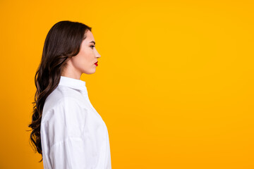 Stylish young woman in a white shirt on an orange backdrop showcasing elegance and charm