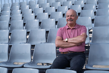 Elderly Man Sitting in an Empty Stadium, Feeling Content