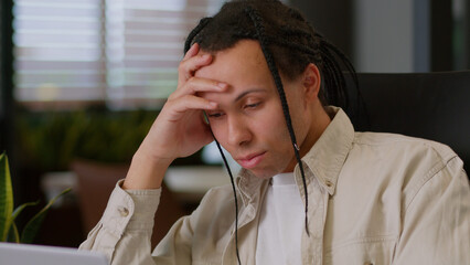 Bored American multiracial business man in office sleepy boredom at workplace indoors working...