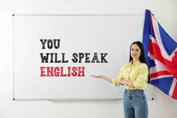 Teacher pointing at text You Will Speak English on whiteboard. Language course