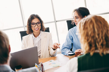 Professional group discussing ideas in a modern office setting showcasing collaboration and...