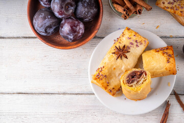 Vertuta, homemade strudel hand pies with sweet plum jam and spicy filling, with cinnamon, on a...