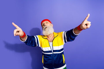 Elderly man in retro sportswear with a vibrant jacket and headband cheering confidently against a...