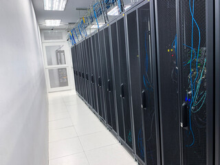 Modern IT server room with rows of black server racks in a high-tech data center environment, showcasing advanced technology, cyber security, and digital infrastructure.