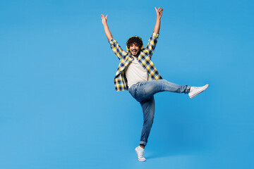 Full body young happy fun cool Indian man wear yellow checkered shirt casual clothes listen to...