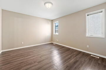 Large, empty room with a wooden floor and a white ceiling