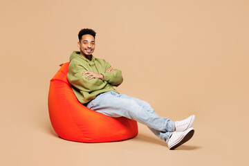 Full body young smiling happy fun man of African American ethnicity wears green hoodie casual...