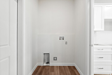 Small, white room with a white door and a white wall
