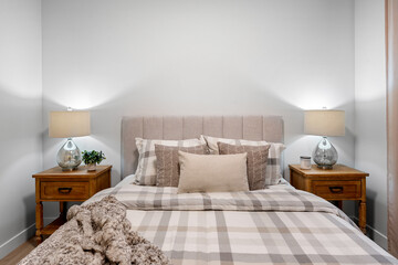 The bed is made with a white comforter and a plaid pattern