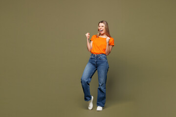 Full body young overjoyed excited fun woman she wears orange t-shirt casual clothes do winner...