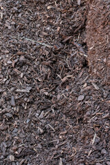 Сlose-up View of a Large Pile of Organic Mulch from Shredded Bark and Wood Chips for Gardening, Landscaping, or Soil Conditioning. 