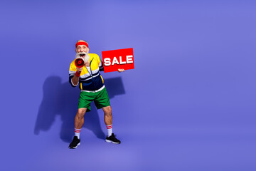 Elderly man in retro sportswear enthusiastically promoting a sale with a megaphone against a...
