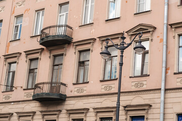 Beautiful pink building showcases intricate architecture featuring charming balconies and vintage...