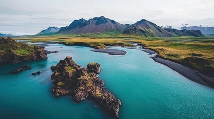 Fototapeta premium Turquoise River Meanders Through Icelandic Landscape, Mountainous Backdrop, Aerial View.