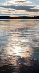 Calm lake reflecting a golden sunset sky.