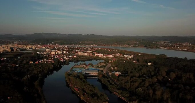 Aerial view of the Olt River winding through the city of Ramnicu Valcea, Romania at sunset