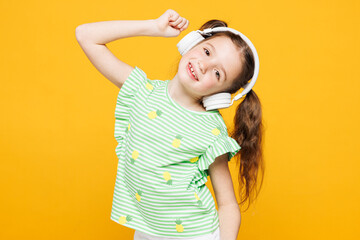 Little smiling cheery fun cute kid child girl 8-9 years old wears green t-shirt listen to music in...