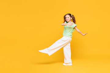 Full body side view little confident cute kid child girl 8-9 years old she wears green t-shirt...