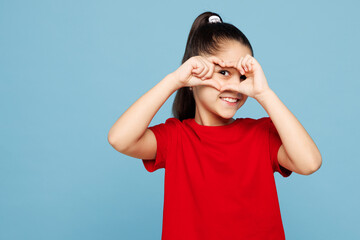 Little kid girl 8-9 years old wearing red t-shirt cover eye with shape heart with hands heart-shape...
