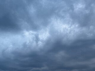 Stormy sky with dark, snowy clouds on a spring day. Clouds are floating across the sky. Dark blue...