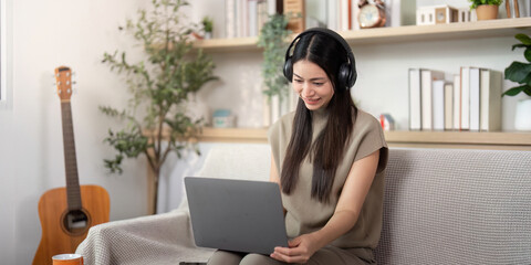 Focused Work. Young woman using a laptop while relaxing at home.