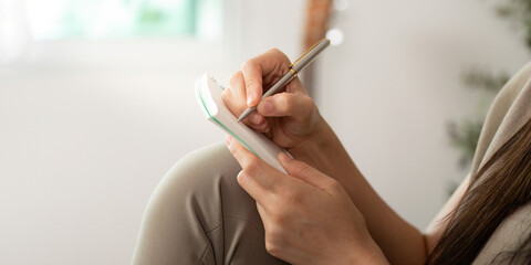 Focused Writing. Close-up of hands writing notes on a digital notepad.