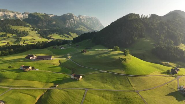 Aerial View of Swiss Countryside Near Hoher Kasten with Green Hills, Meadows, and Mountains at Sunset