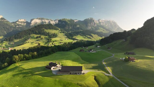 Aerial View of Swiss Countryside Near Hoher Kasten with Green Hills, Meadows, and Mountains at Sunset