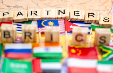 A Brics and Brics Partners concept with letter tiles and country flags on a world map background.
