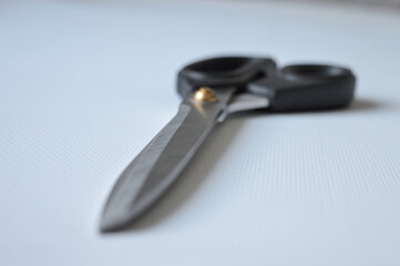 hand holding large metal scissors with black handle  ideal for themes like sewing, crafting,...